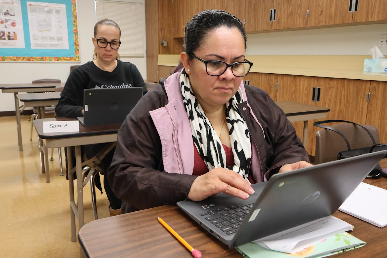 Students sitting in a classroom working on their laptop